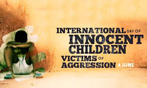 Seated child with head down against orange wall. Text: "International Day of Innocent Children Victims of Aggression, 4 June." Somber mood.