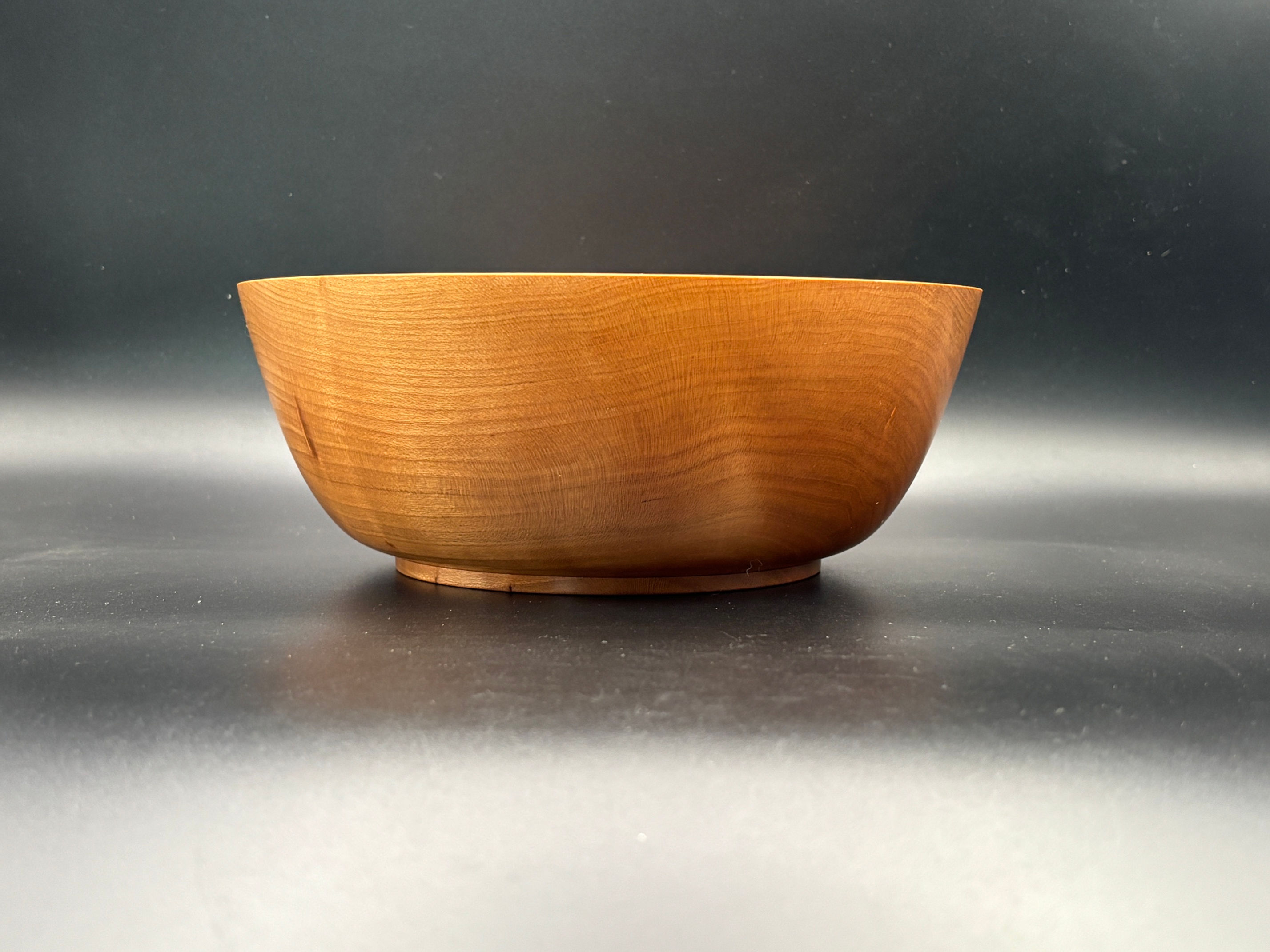 Handcrafted from a beautiful piece of cherry wood, this piece celebrates the natural character of the tree.