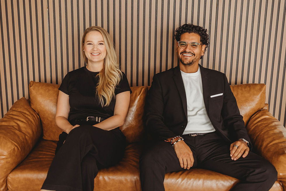 April and Juan Felipe, the talented founders of Markle+Diaz, pose together on a stylish leather couch, embodying creativity and leadership.