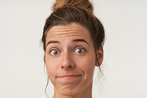 close-up-attractive-young-woman-posing-with-bewildered-face-wearing-bun-hairstyle-no-make-