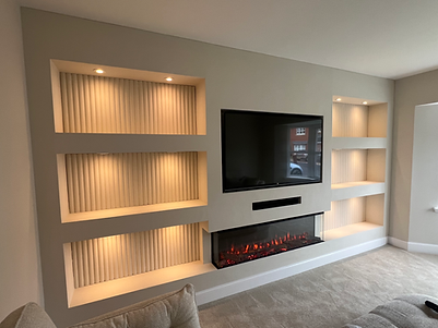 Bespoke media wall in glasgow with Electric media wall fire and shelving with luxurious wall panelling.