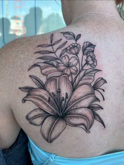 Black and white floral tattoo on a person's shoulder