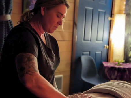 person receiving a massage in a dimly lit room with fairy lights. Calm and relaxing atmosphere
