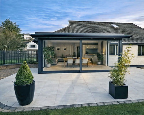 Contemporary single‑storey extension in Belfast by GT Building Design, with full‑width glazing and tiled patio.
