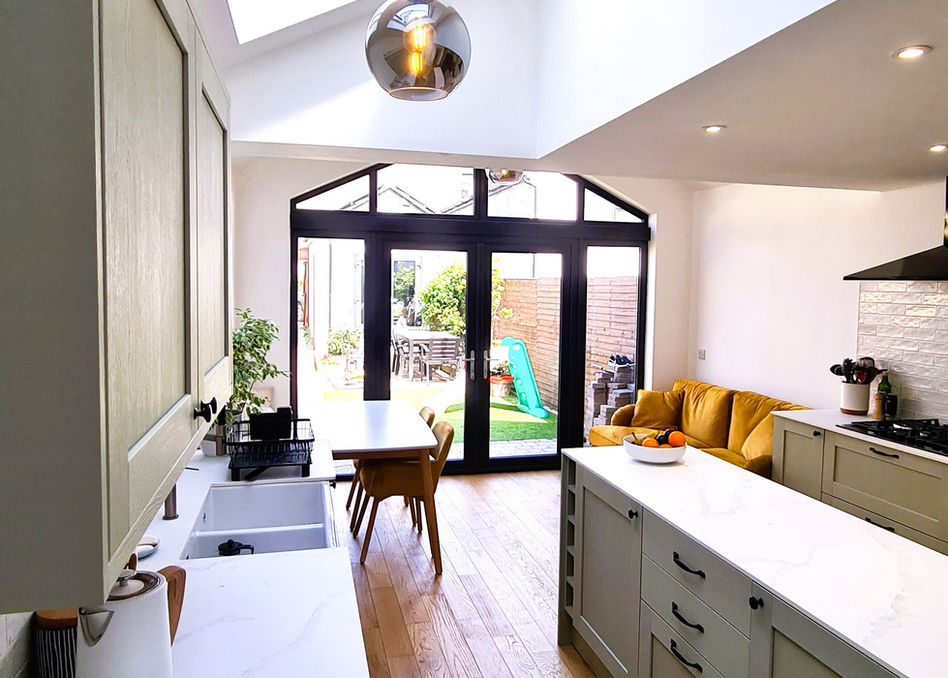 Rear extension kitchen design with island and rooflights providing natural light in Bangor.