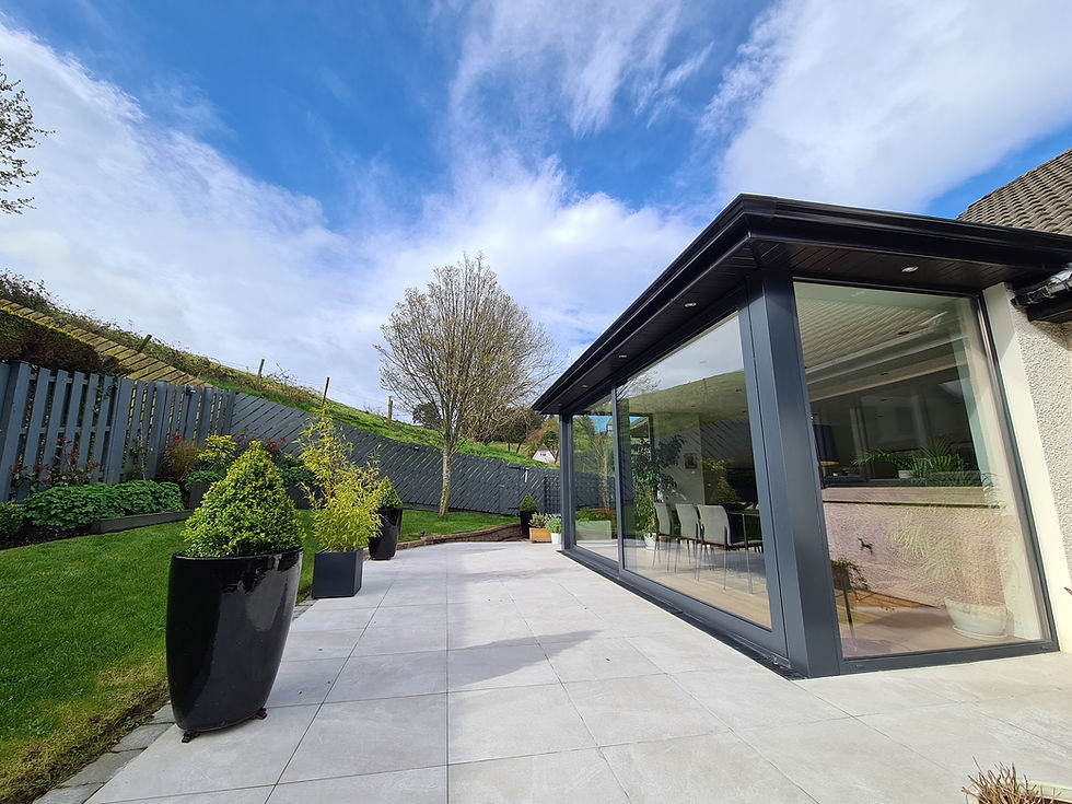 Modern glazed extension in Belfast by GT Building Design — patio view showing large windows and garden landscaping.