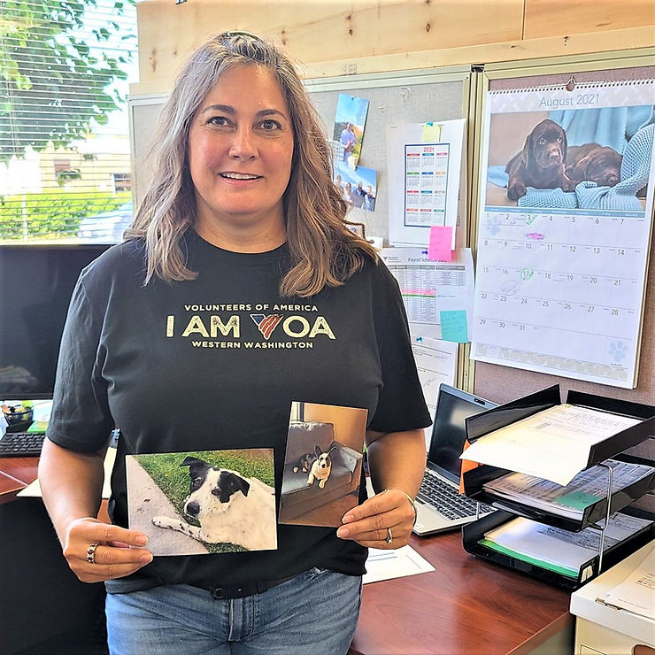 Chris Silverwood holding up two photos of her dogs