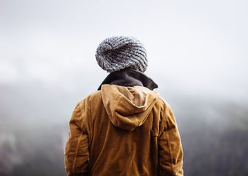 Image of a person in yellow jacket walking away and into fog