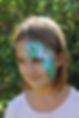 Cute winged unicorn face painting with purple and teal. Painted by Brisbane face painter Beth Joyce.