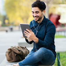 portrait-young-man-having-video-call-digital-tablet-while-sitting-bench-outdoors-urban-con