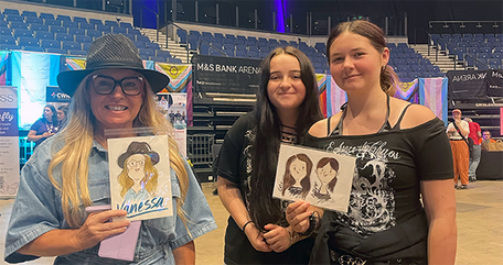 Three people holding up caricatures at M&S Bank Arena