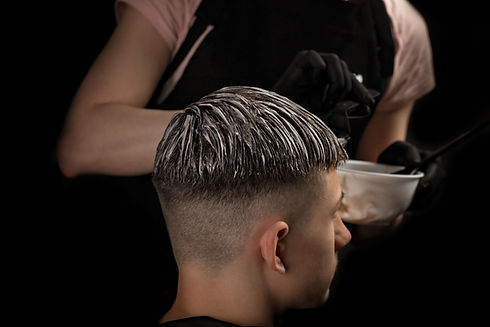 Professional hairstyle. Model and trendy hairdressed. Barber is coloring male hair. Handsome guy in barbershop. Young man with new haircut. ..jpg