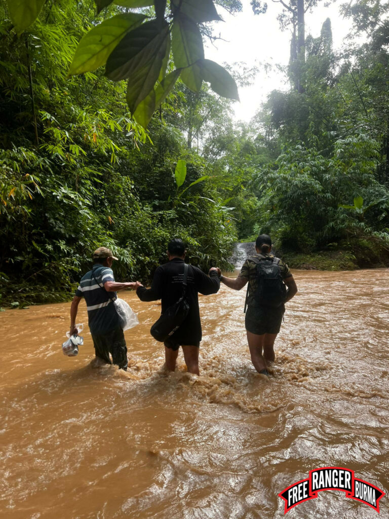 FBR volunteers wading on the road during rainy season in Karen State.