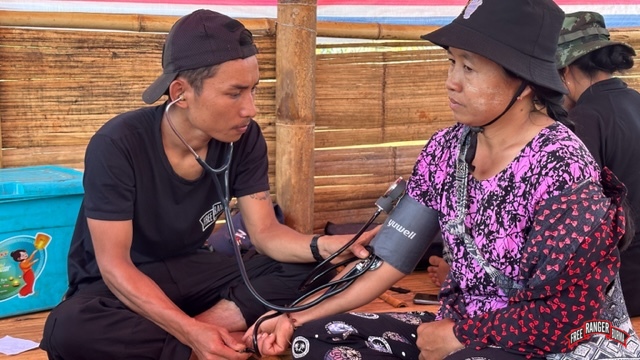 FBR medic treats a displaced Karenni woman in a hiding place.