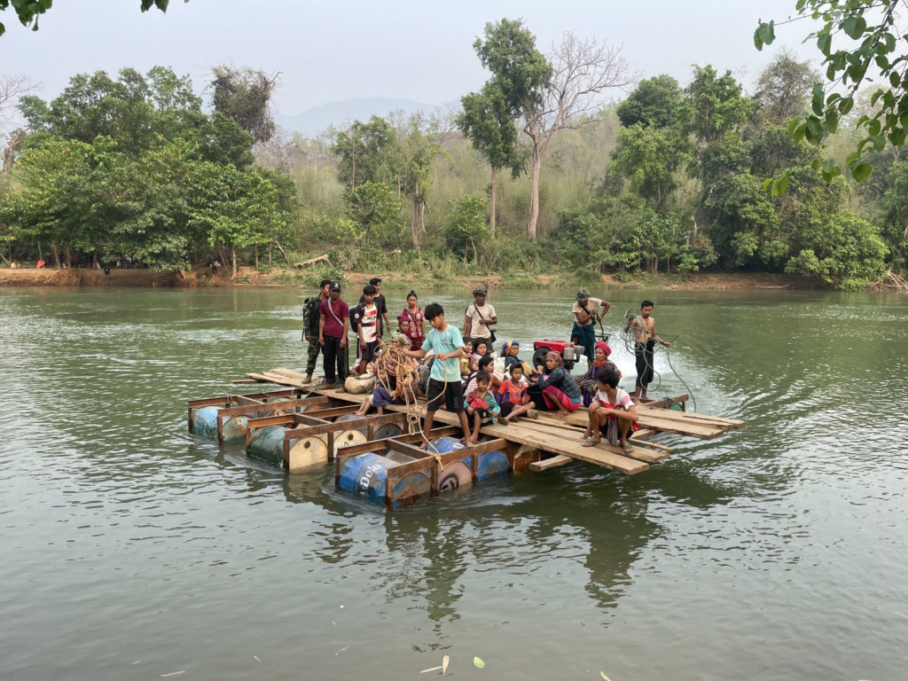 A raft is used to move IDPs across the Pon River as they flee from fighting in their villages.
