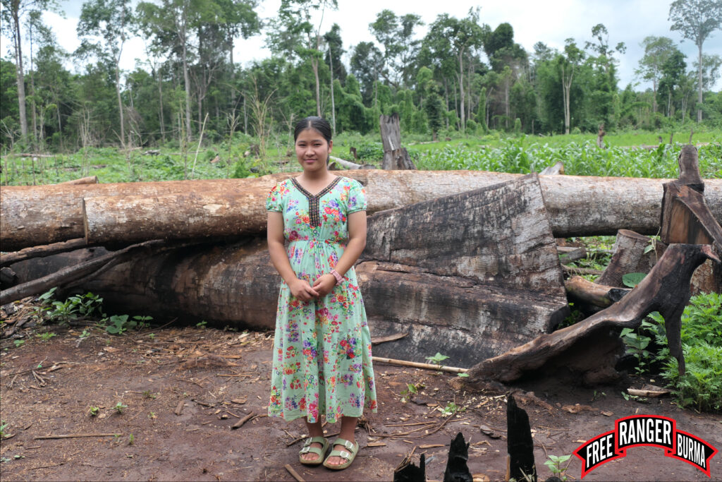 So Layar Moo, a 9th grader, in front of the fields the high school students farm for food.