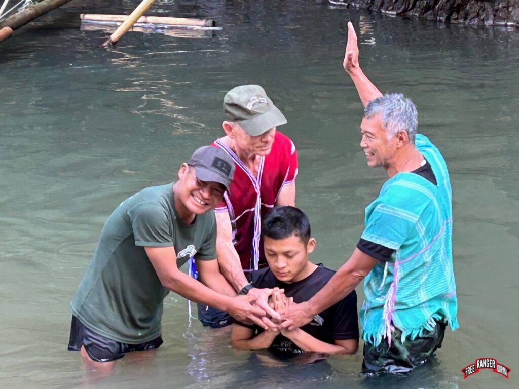 Monkey, Dave, and Pastor Edmond baptize Monkey's son.