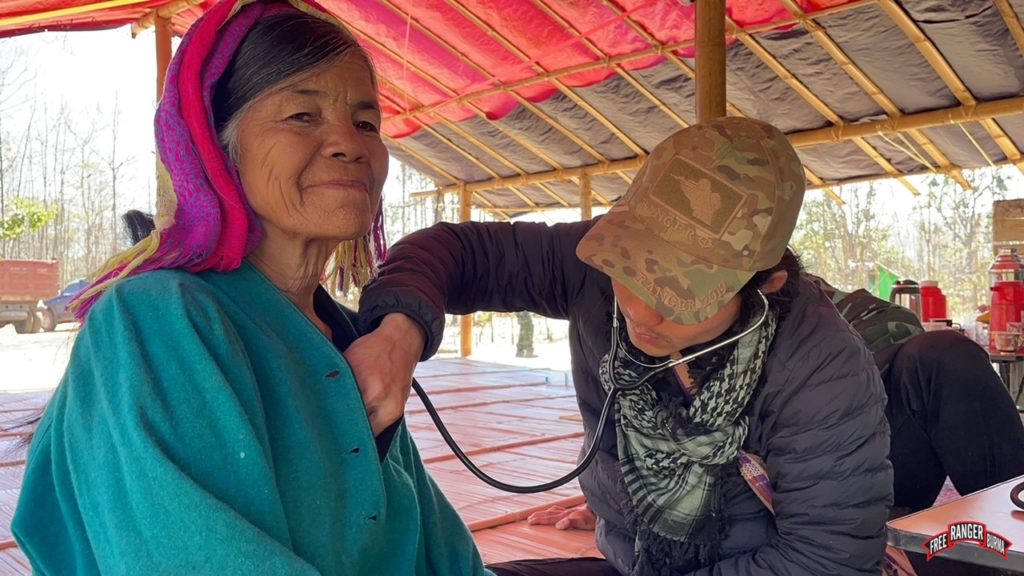 Ranger provides medical aid to a displaced woman in an IDP camp outside of Demoso.