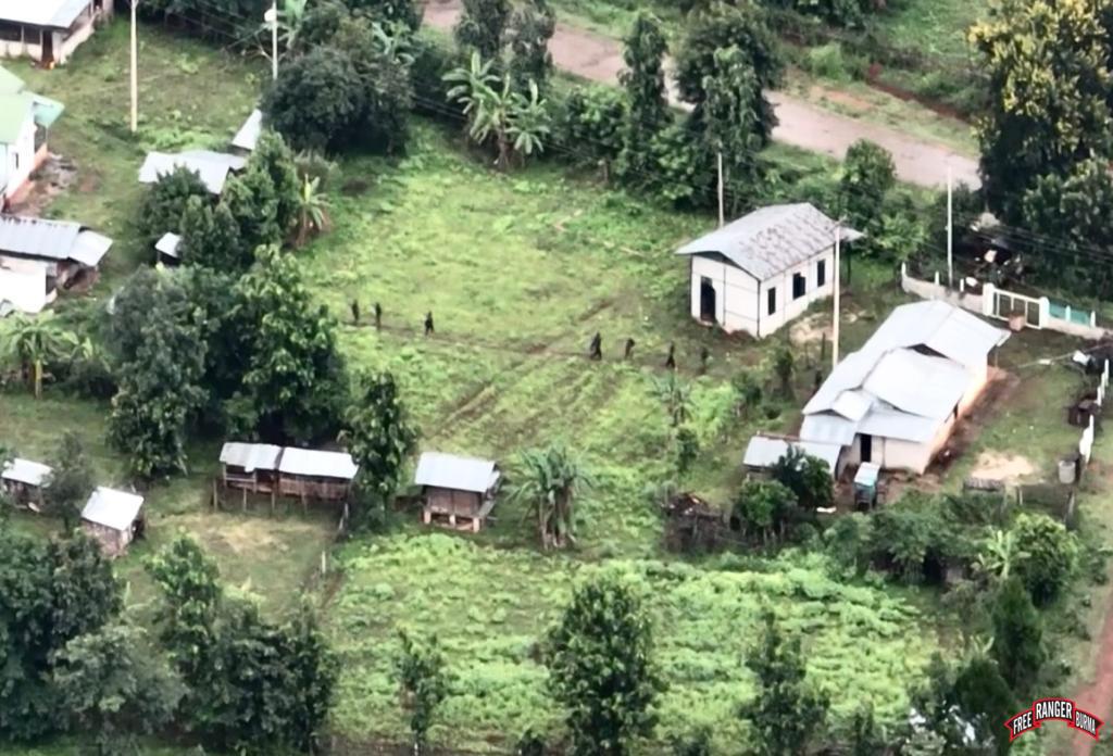 Burman Army troops of Division 66 moving through the village as they burn it.