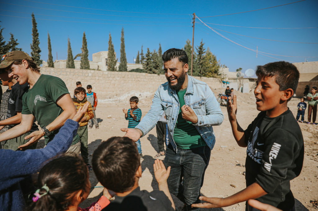 Teacher Adbul Sattar from Dadat School, dancing with children displaced by war but who still have hope.