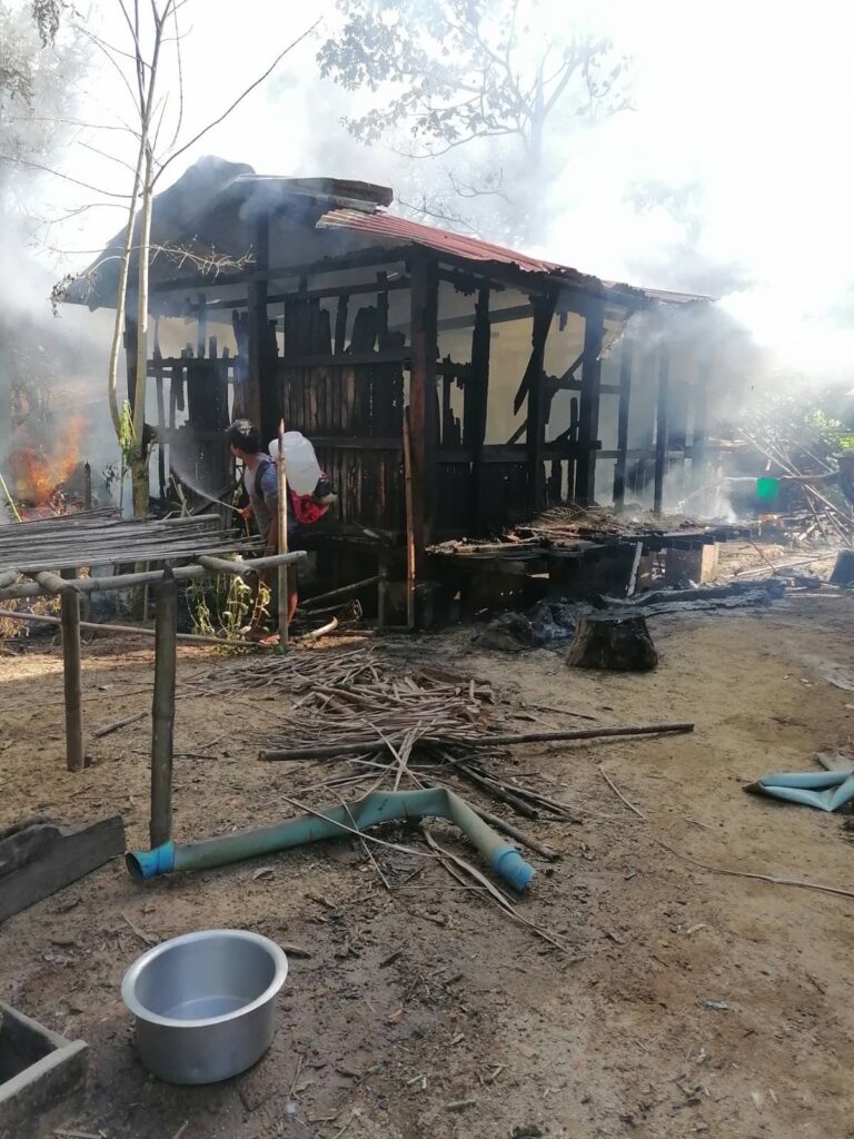 After airstrikes destroyed his home in Yin Le Village, a man works to put out the fire. 