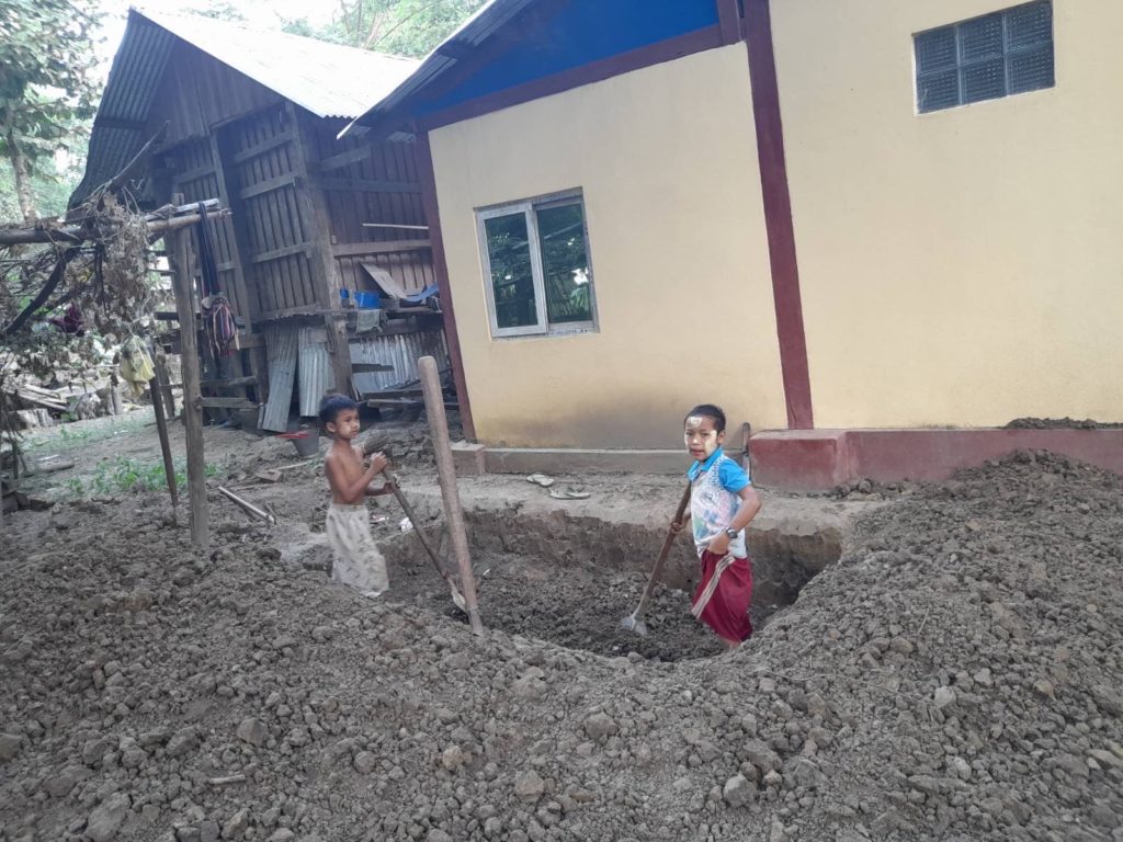 Children helping to dig a bomb shelter near their home.
