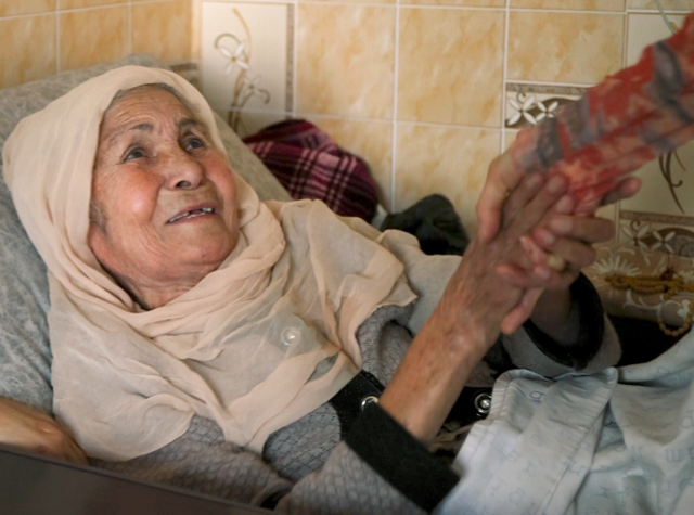 Praying with an Afghan refugee woman