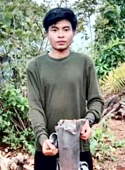 Fransico holding up a rocket the Burma Army had fired into a village.