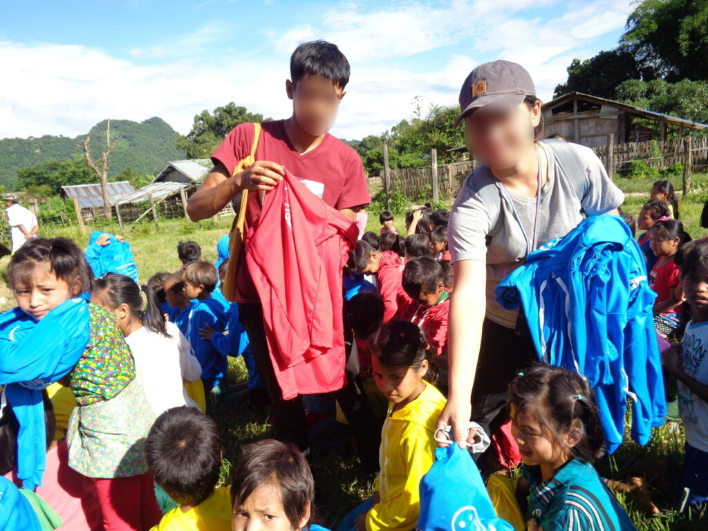 Nu handing out GLC shirts to children in Shan State, Burma.