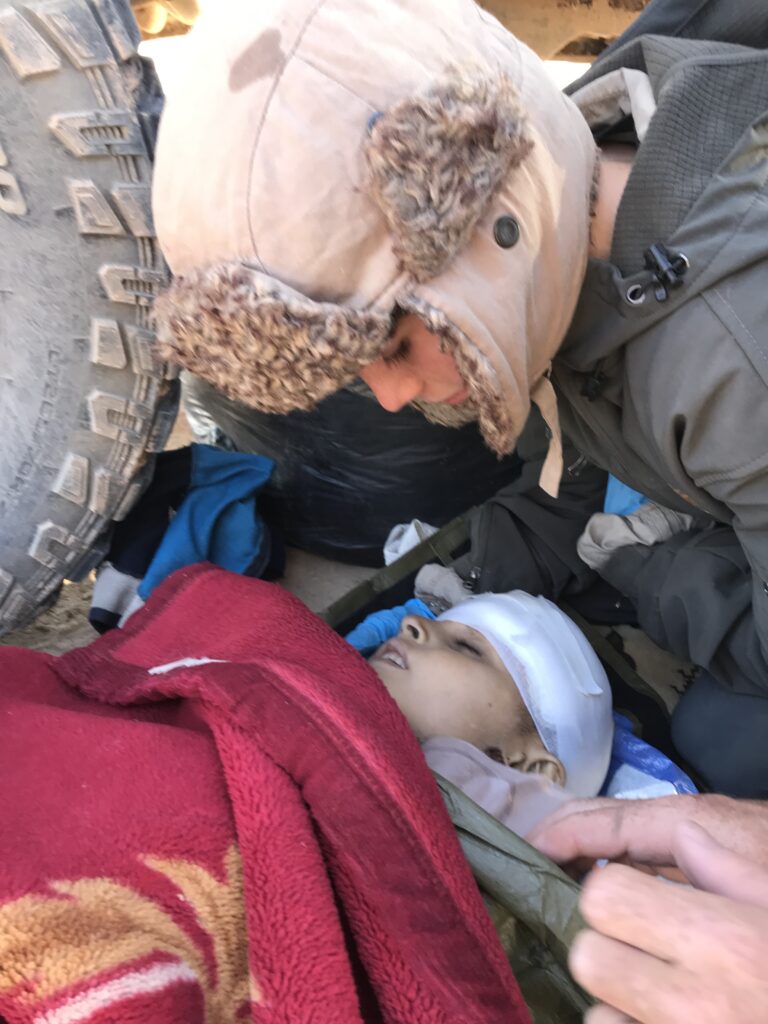 Peter comforts wounded ISIS child in Syria.