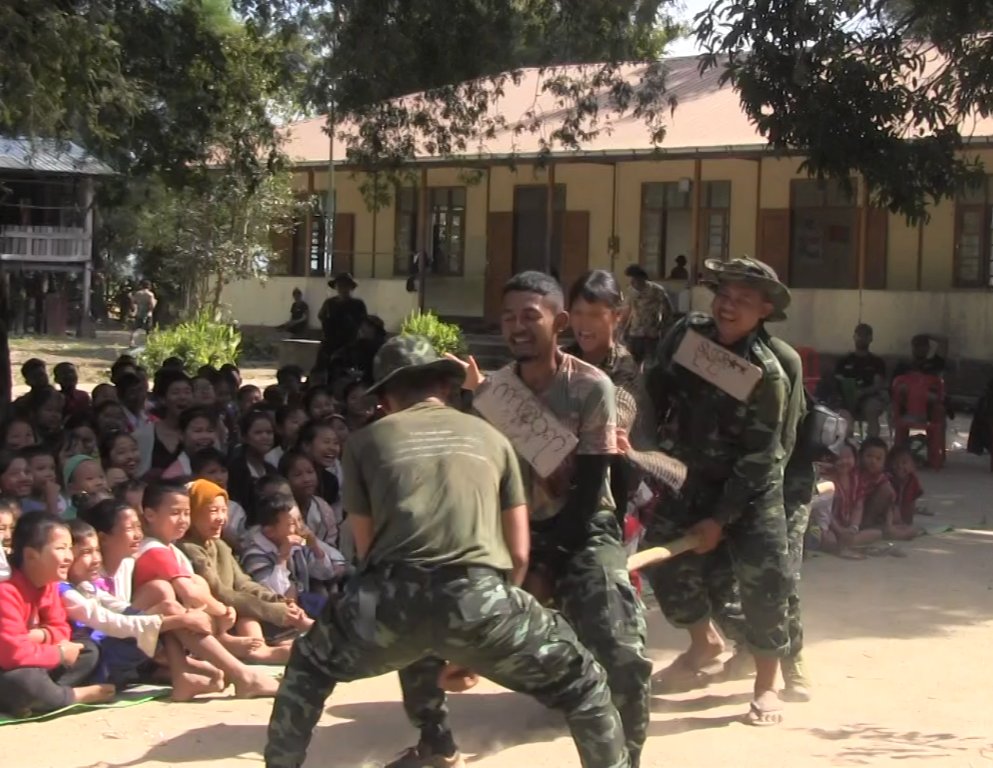Paing So, in the middle wearing a hat and sign, putting on the "Jesus on the Bus" skit with his teammates