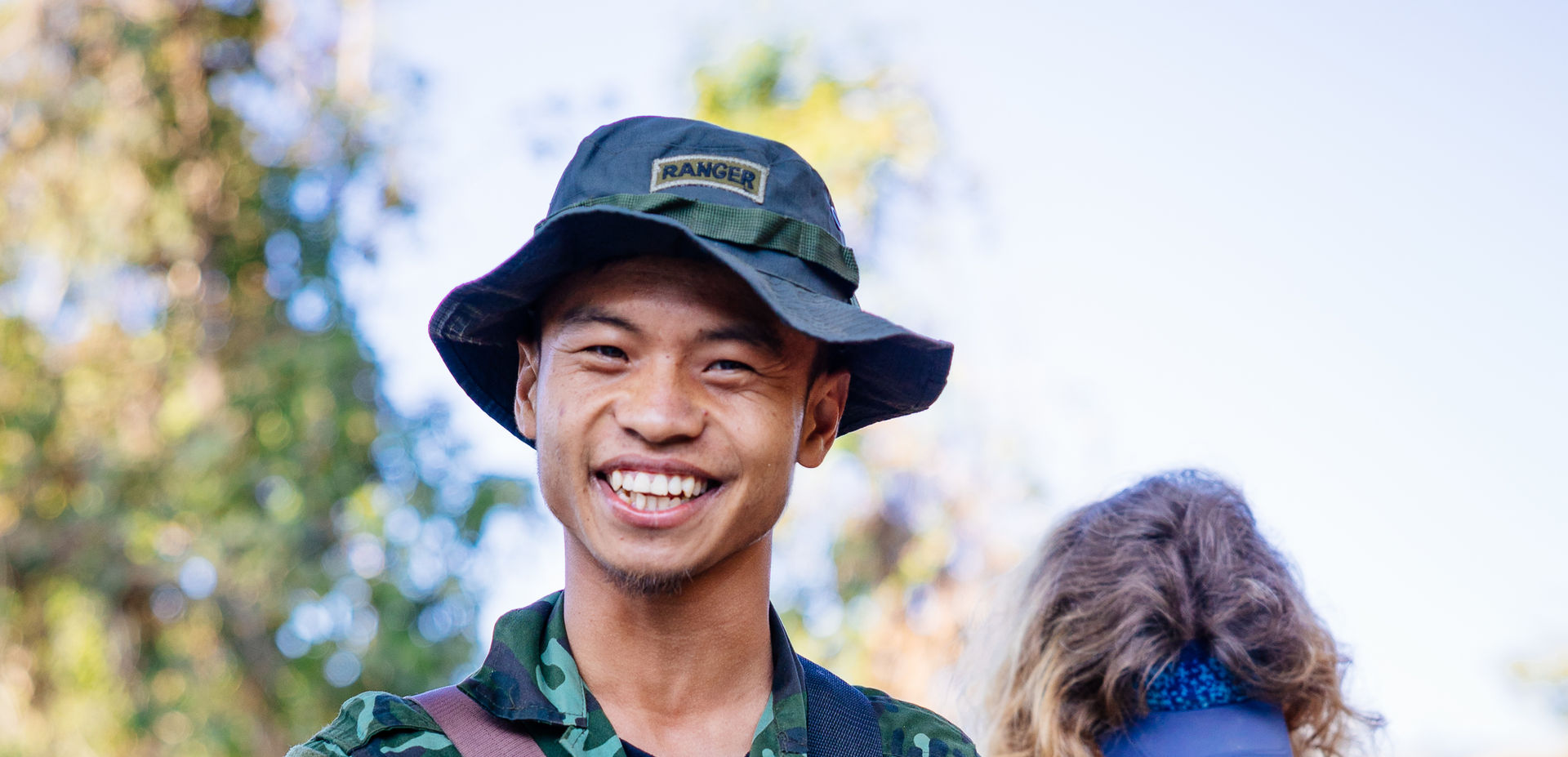 A Ranger from Burma holds a guitar and smiles
