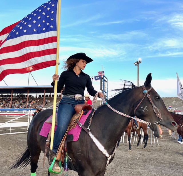 Suu rides the American flag during the Star-Spangled Banner at Cody Night Rodeo, Wyoming.