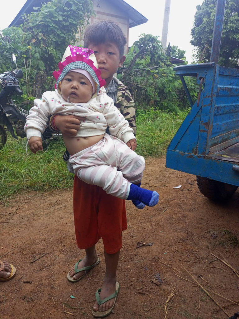Maung Kyae Lwin Oo, 8 years old, and Mu Ann Jalar, 6 months. The picture was taken at their parents' funeral.
