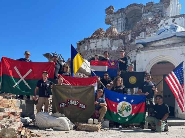 Flags of Ukraine, USA and friends in Burma in the ruins of a church destroyed by Russian tank fire.