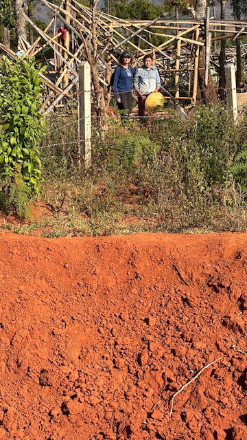 Karen with a Karenni IDP behind a crater from a Burma military bomb that killed her neighbors in their home and destroyed her home as well.