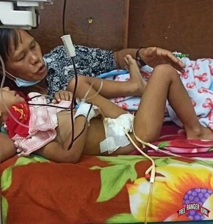 The father lays next to his son in a hospital bed. 