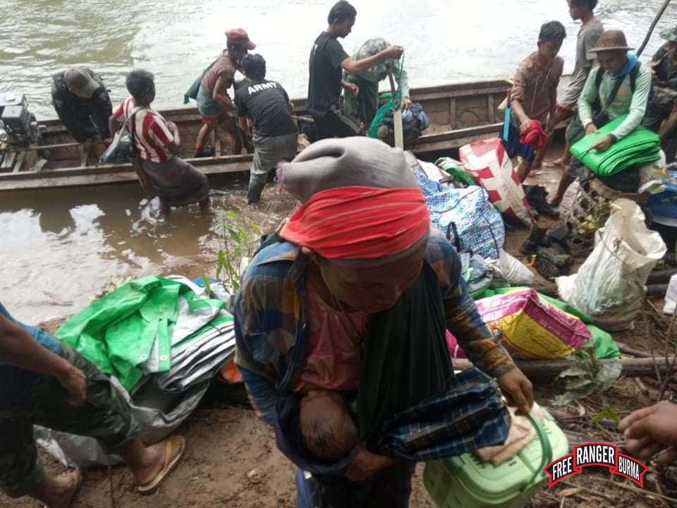 Villagers fleeing by boat arrive at a hide site