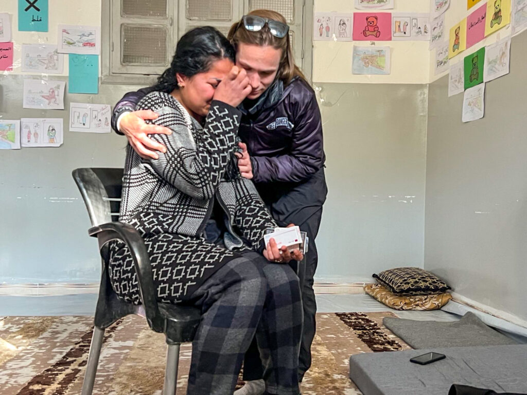 Natasha comforts an IDP woman.