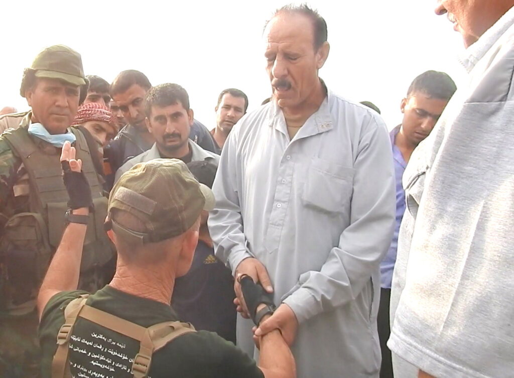 Kneeling in front of the older brother and villagers and asking forgiveness.