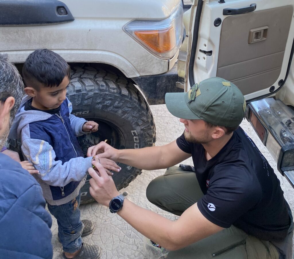 Giving a gospel bracelet a young IDP to remind him he is loved by Jesus.