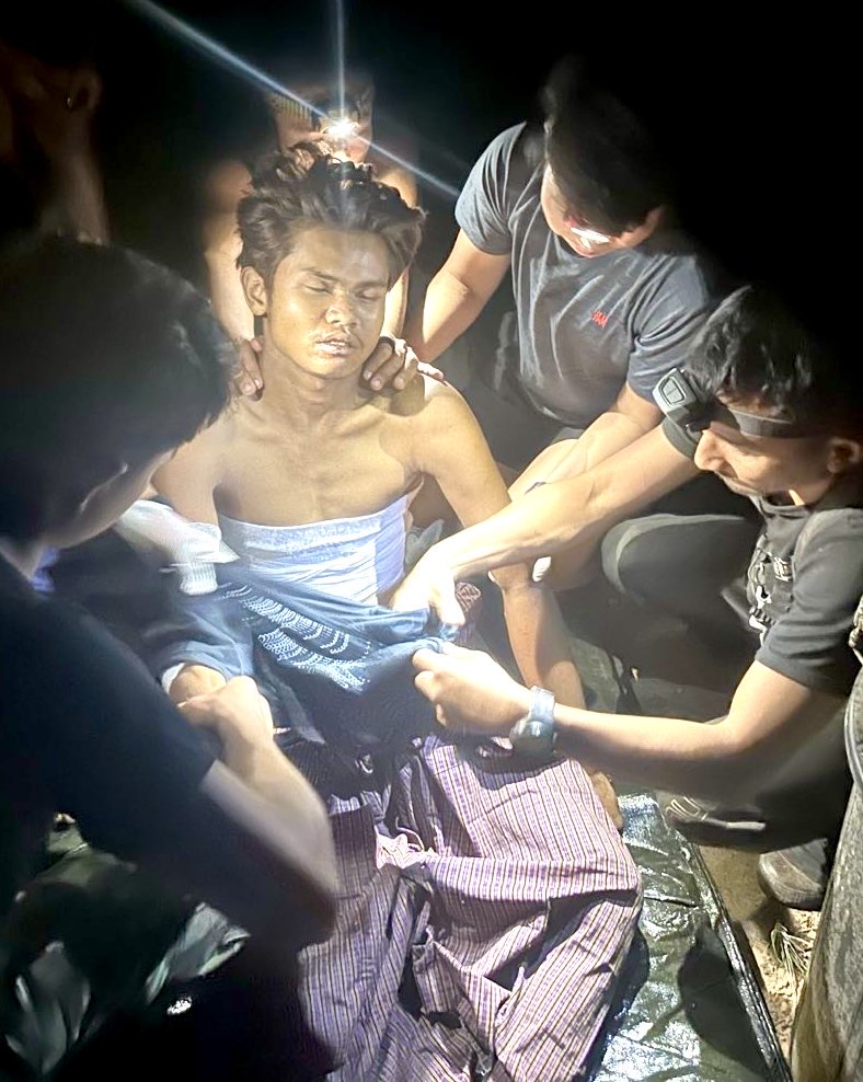 Sai Tway's team prepares his body for burial.