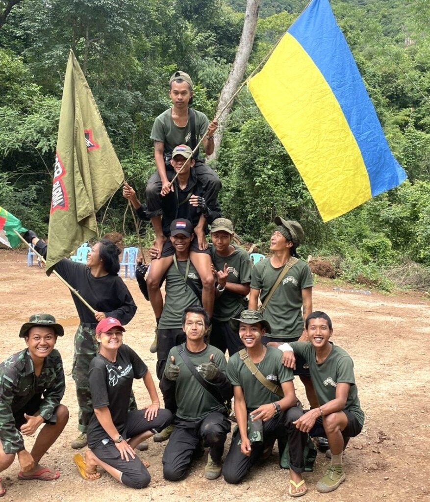 Kyaw Gyi, smiling even with two men on his shoulders.