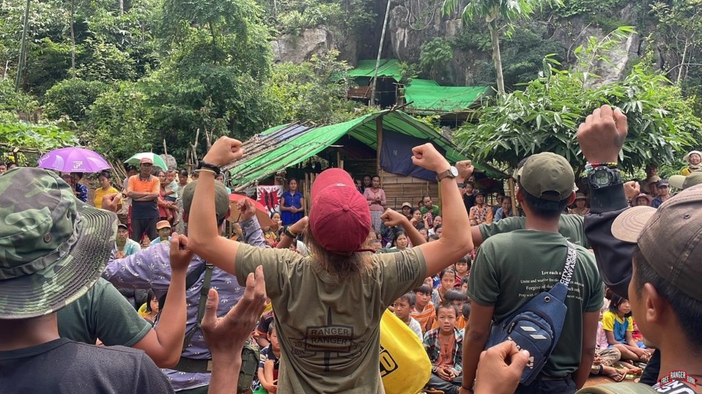 Team leading songs at hiding place before relief distribution.