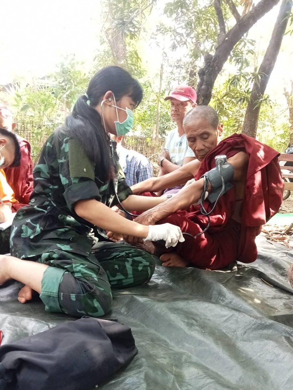 An FBR medic treats a monk who was displaced by the fighting.