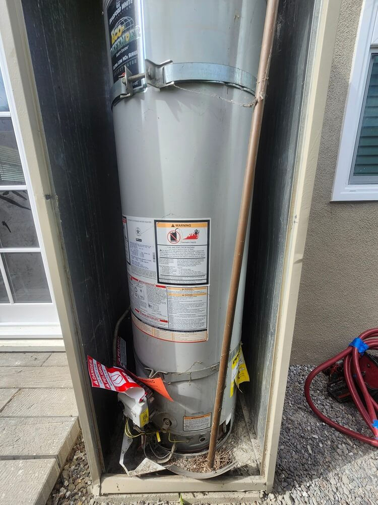Existing gas water heater before replacement during a residential water heater project in Altadena, California.