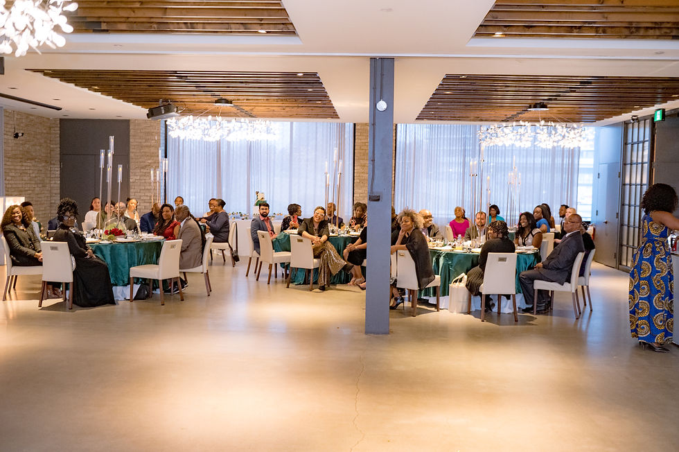 Group of people at a formal event inside a venue with tables.