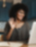 Smiling woman waves during a video call with a laptop and earbuds in kitchen.