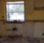Kitchen renovation with stripped walls and window