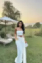 femme portant une robe longue blanche en mélange coton élasthanne bustier et fendue pour un événement chic